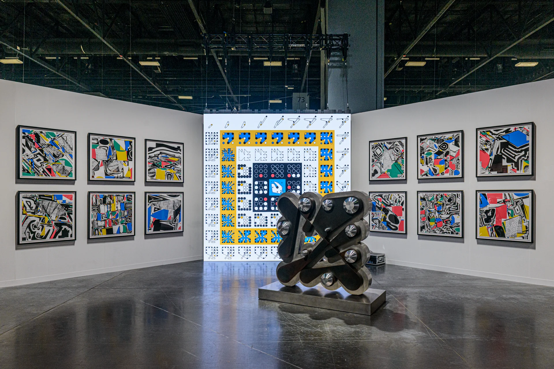 A view of the full installation, with a yellow and blue composition on the screen behind Floor Ringer.