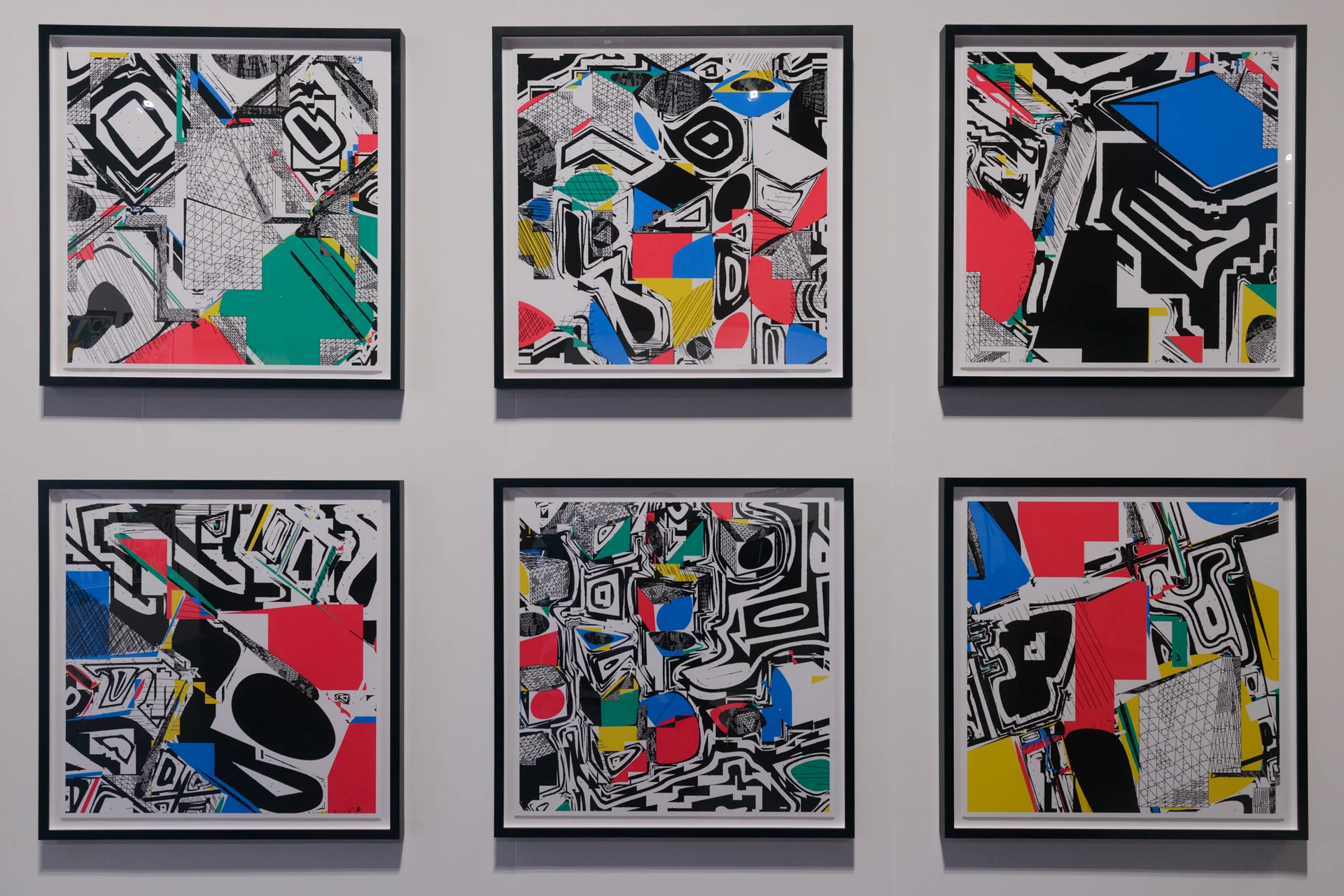 Six framed Polygon Etcetera prints arranged in two rows on the right wall of the booth.