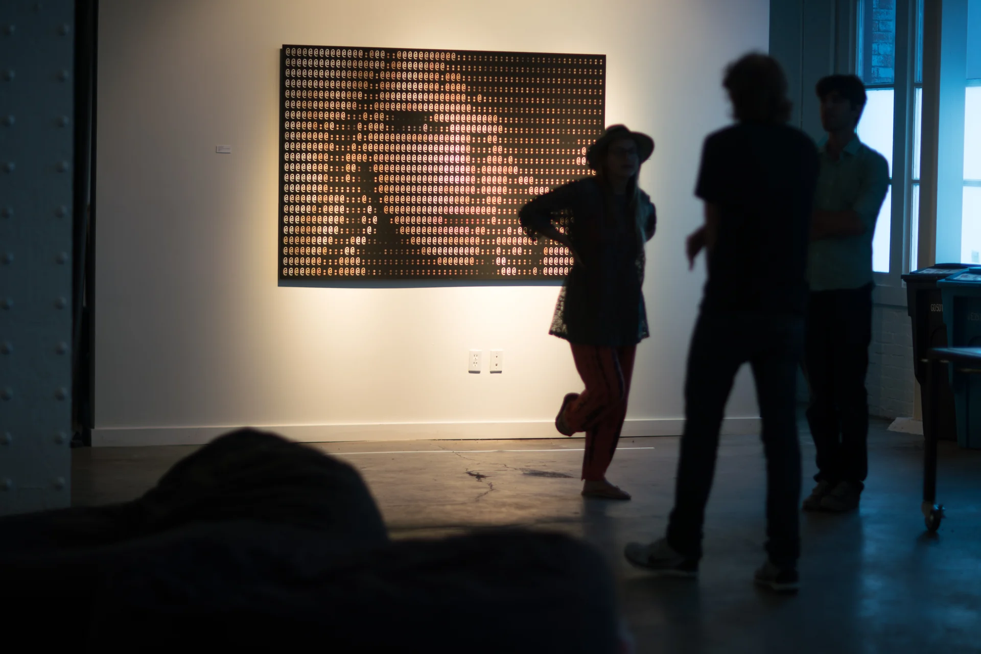 Visitors in front of an ASCII portrait.