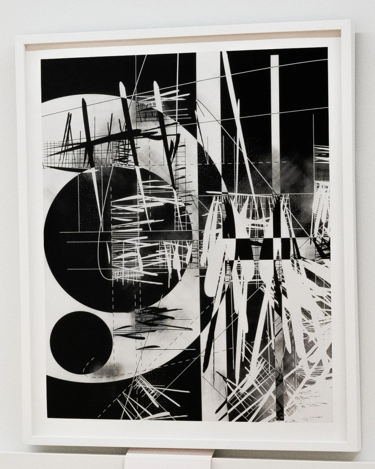 A framed black-and-white photogram: large black and white circles crossed by fine lines, grids, and bursts of white strokes.