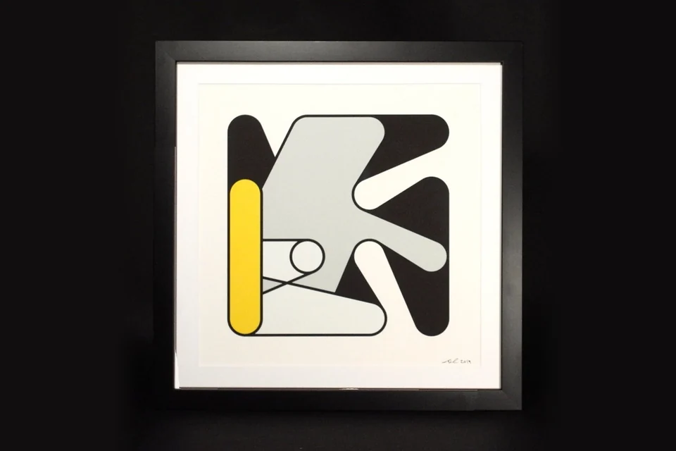 A framed print of Turbulent Figures, Step I, against a black background: overlapping charcoal and grey rounded forms with a tall yellow bar at the left, on a white sheet signed and dated 2019 at the lower right.