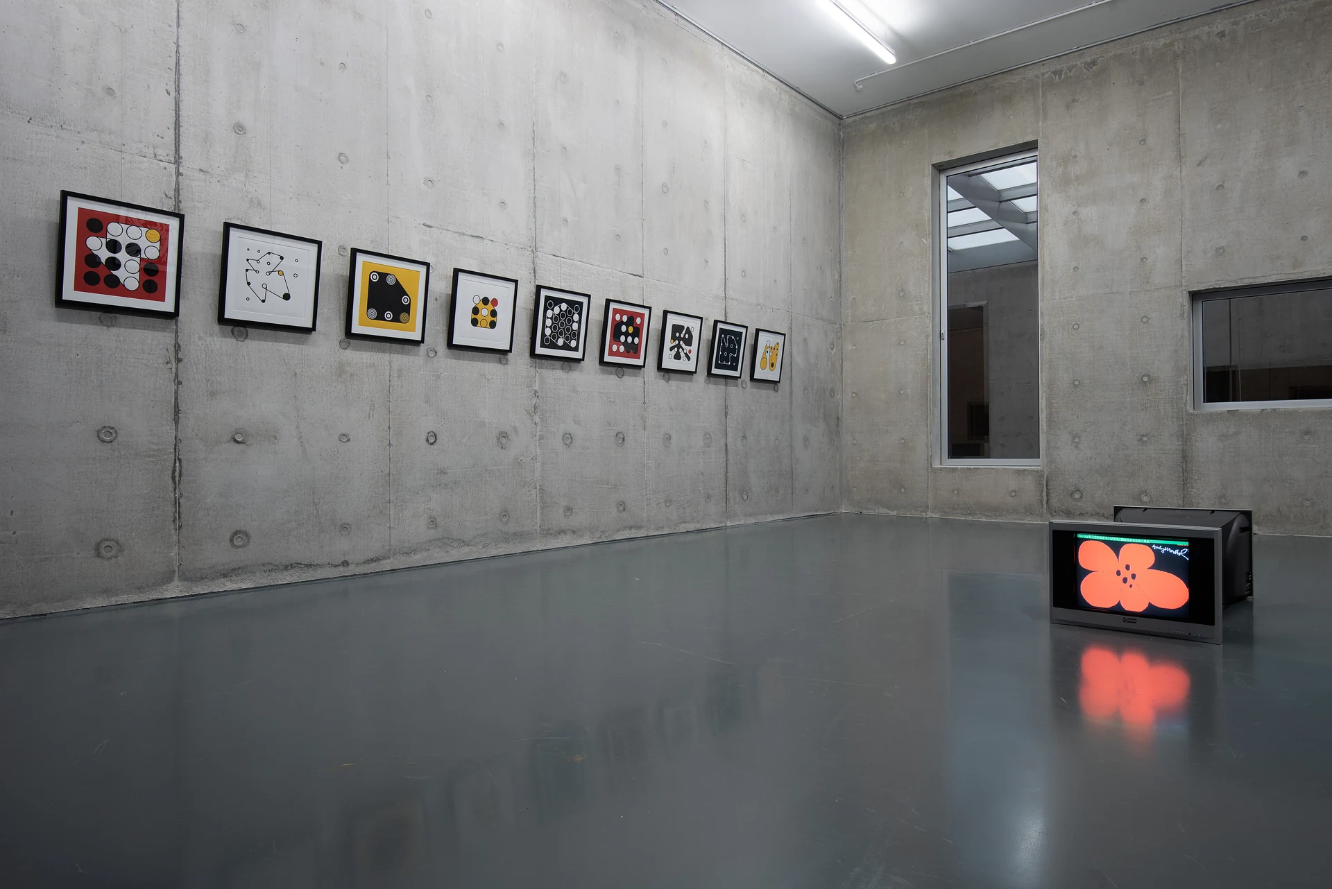 A row of framed Ringers prints displayed on a concrete wall at Le Freeport, Singapore.