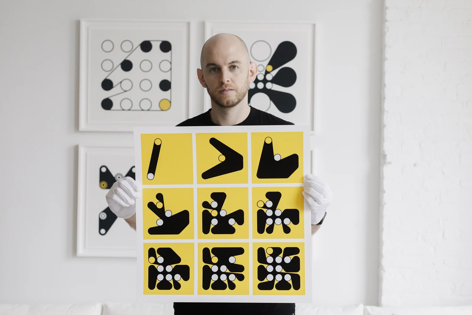 Dmitri Cherniak holding the three-by-three print in his studio.