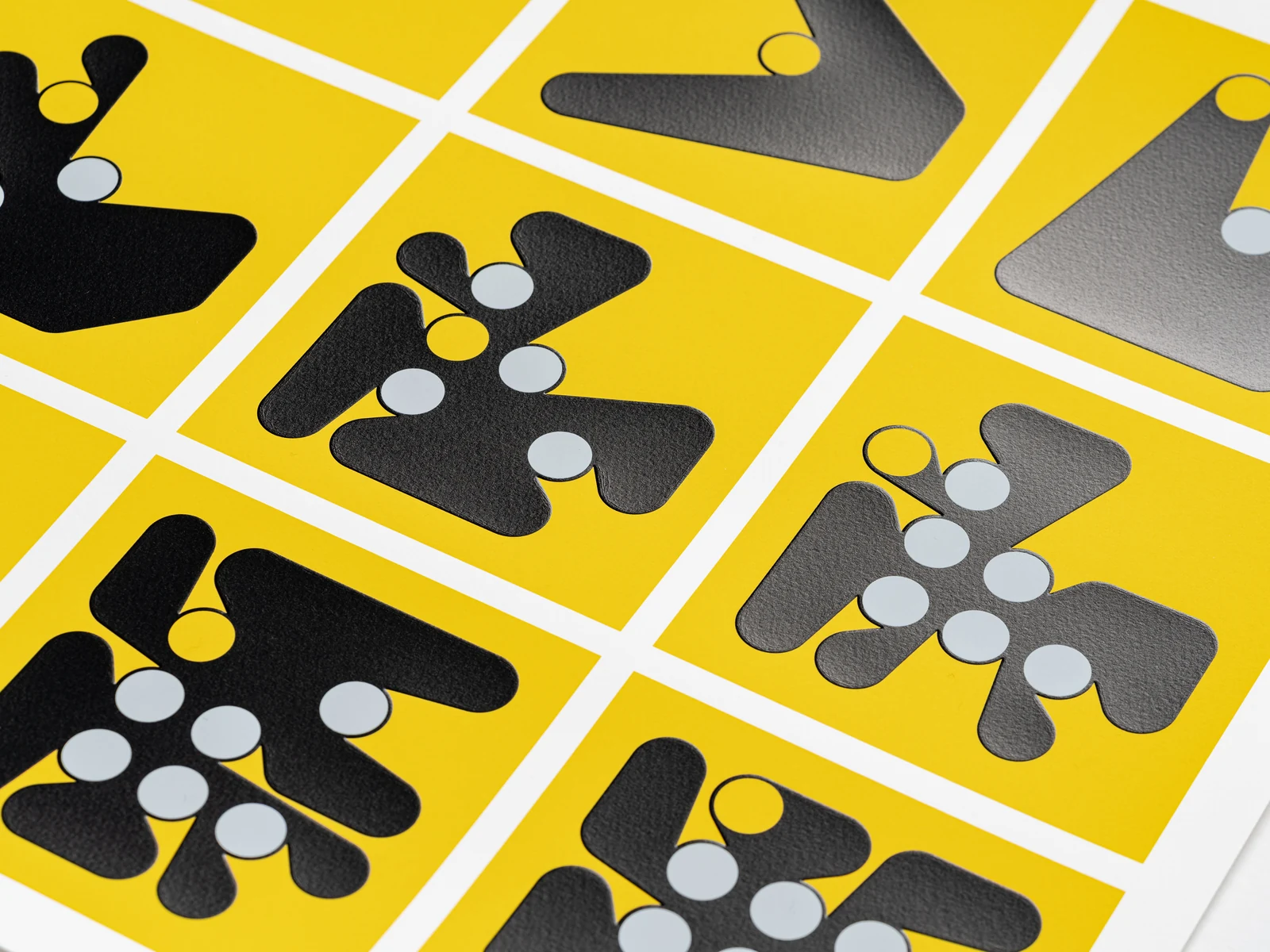 Black Ringer shapes and white circular pegs raised above yellow squares.