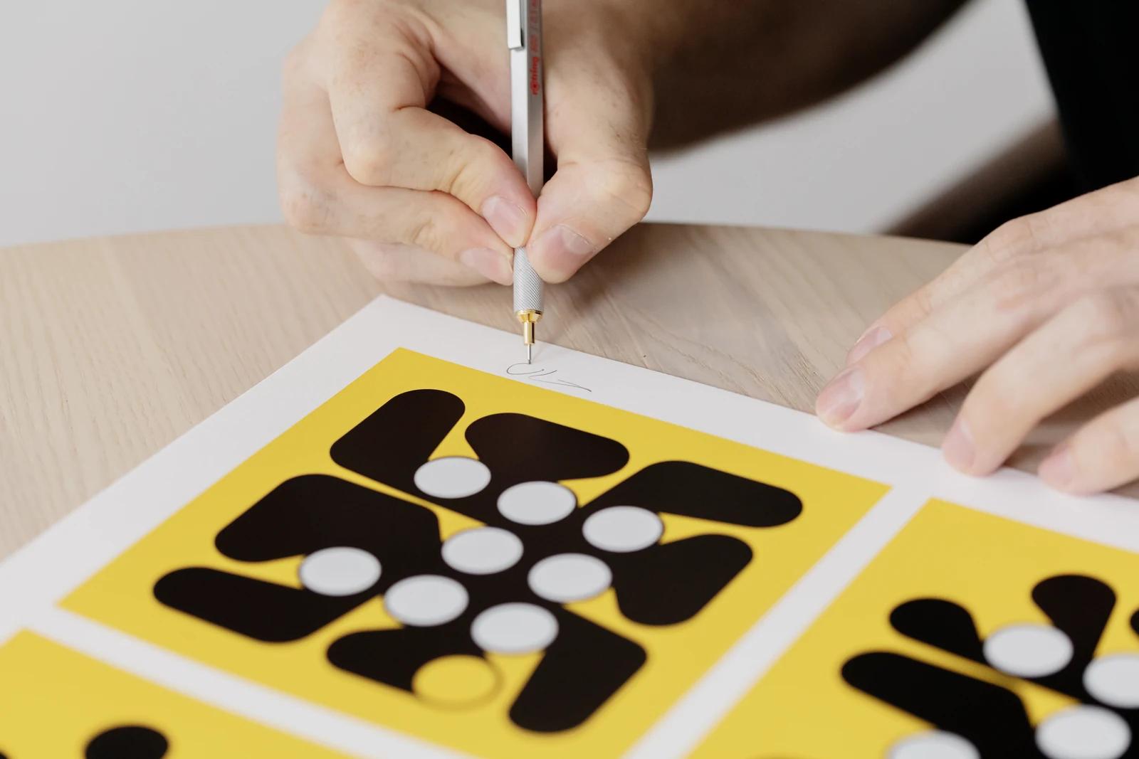 Dmitri Cherniak signing the lower margin of a LACMA Iterations print.